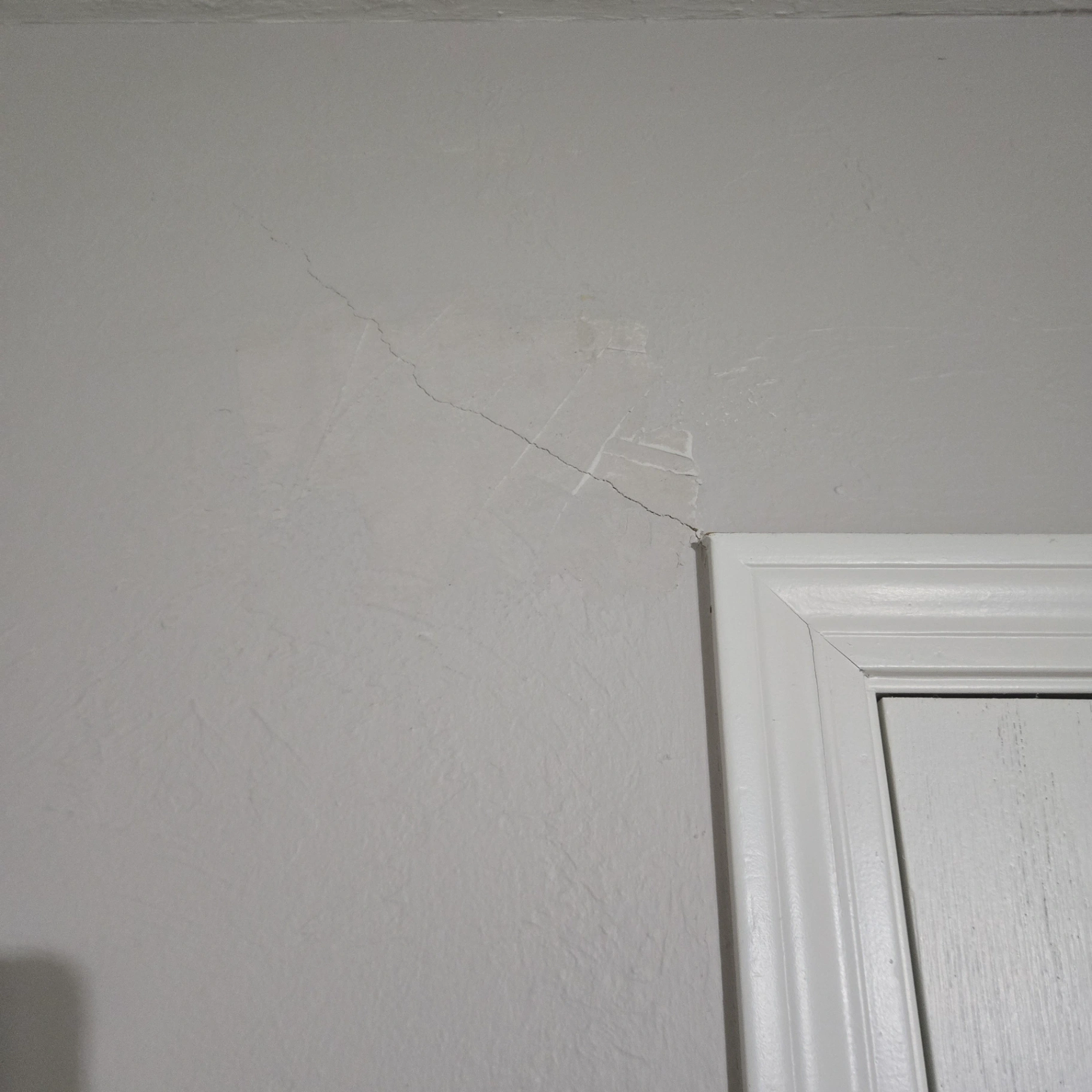 Drywall crack near door frame requiring professional repair in Stillwater home
