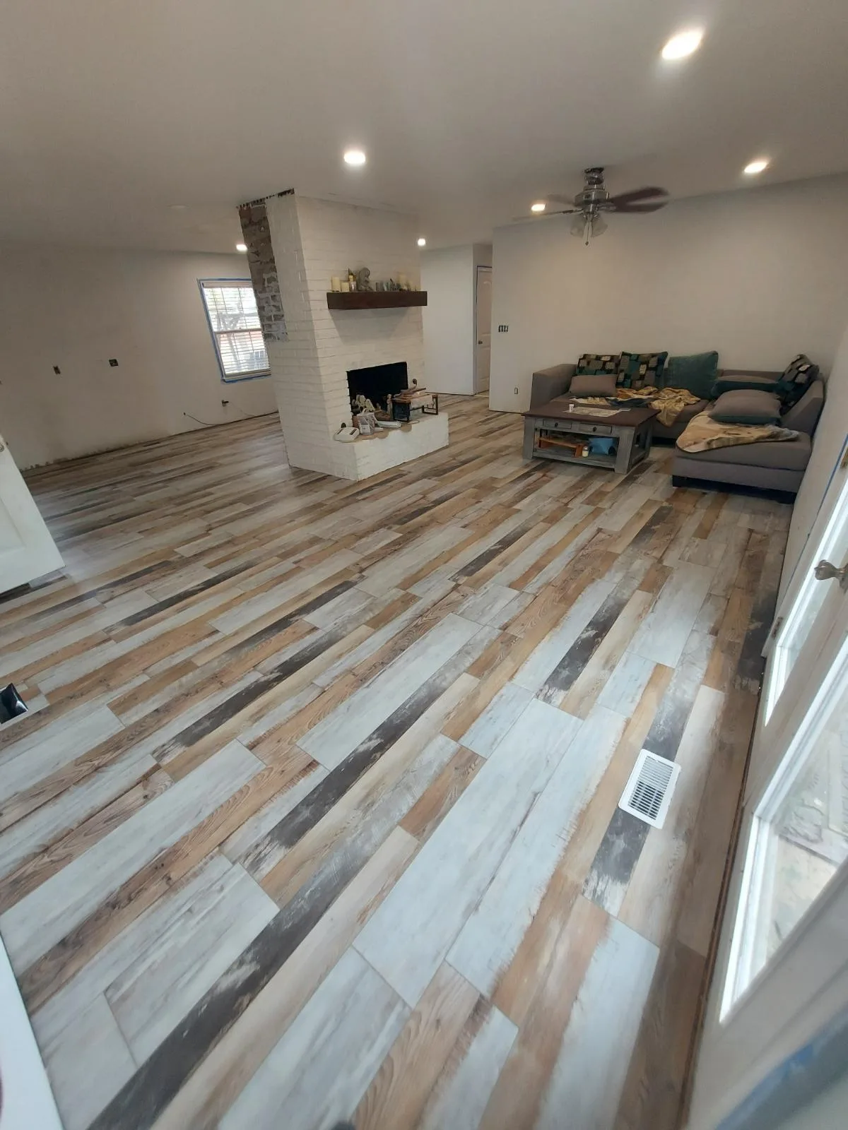 Living room with new wood-look flooring and fireplace completed by Stillwater Handymen LLC