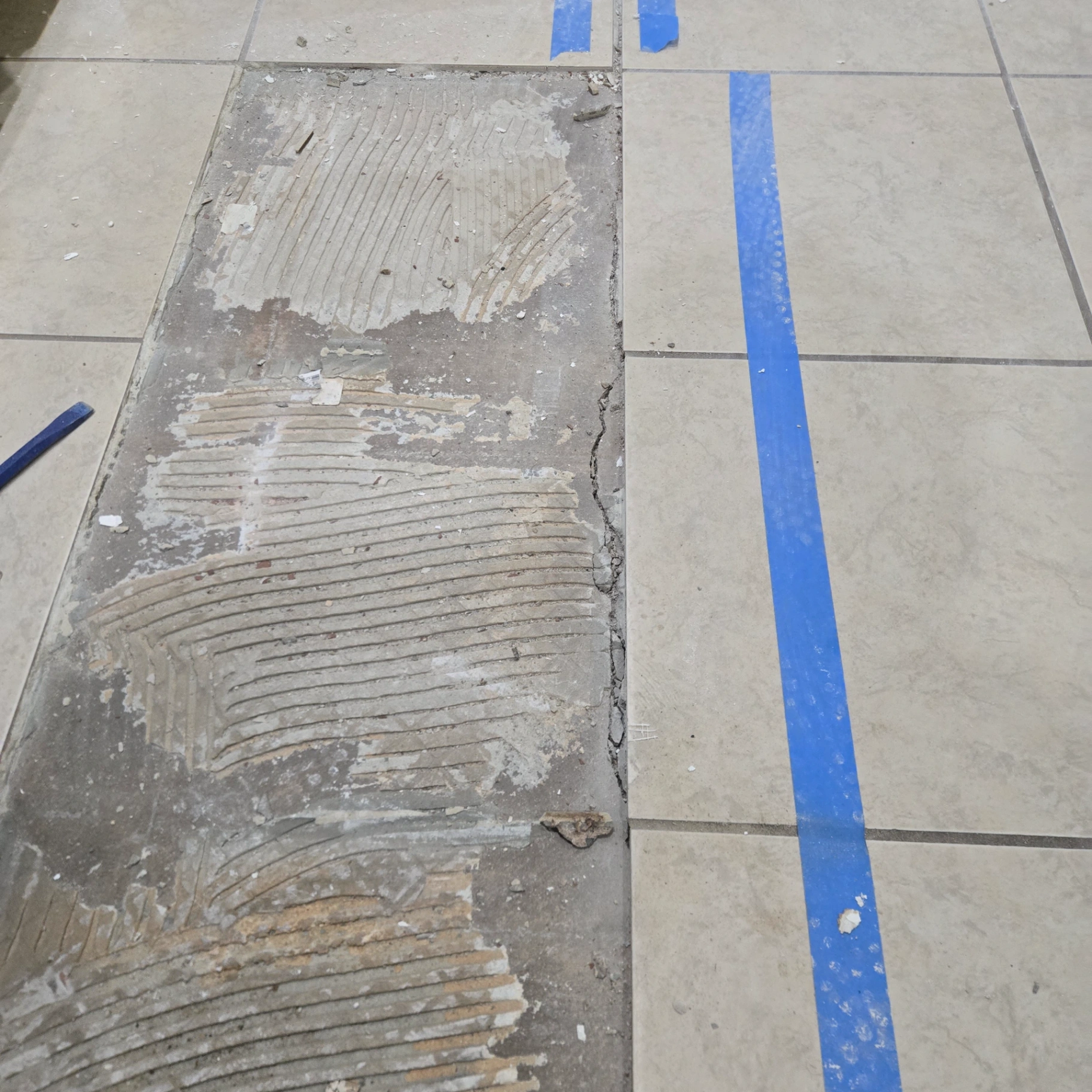 Floor tile removal exposing concrete subfloor during renovation in Orlando