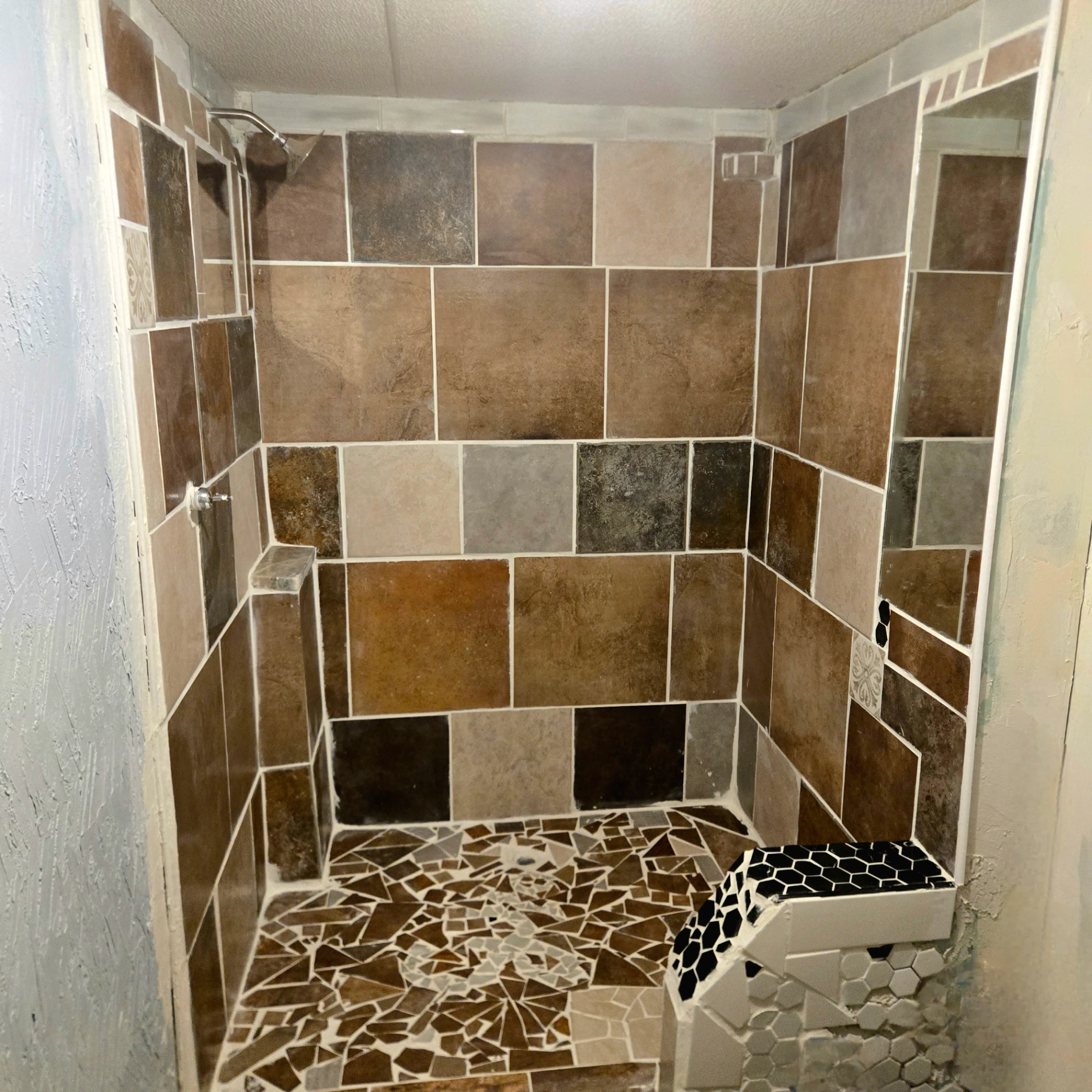 Custom tile shower installation with earth-tone tiles in Perkins Oklahoma bathroom