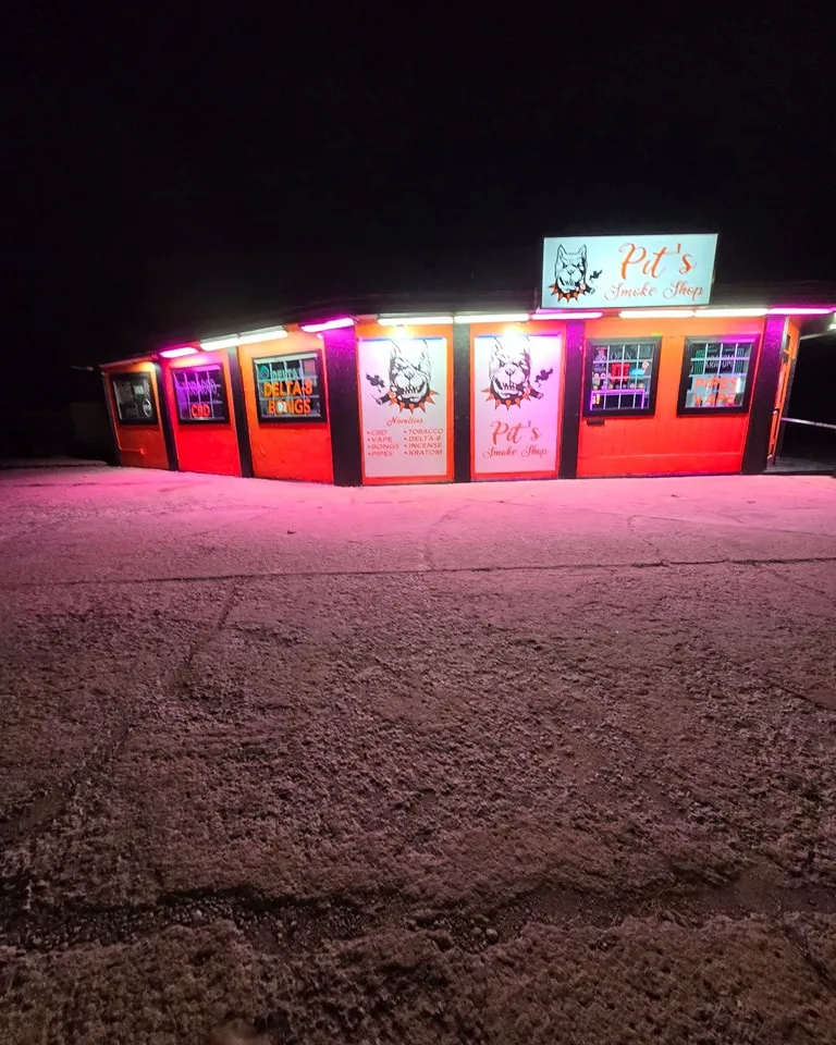 Pit's Smoke Shop completed exterior showing bright orange building with cars in front