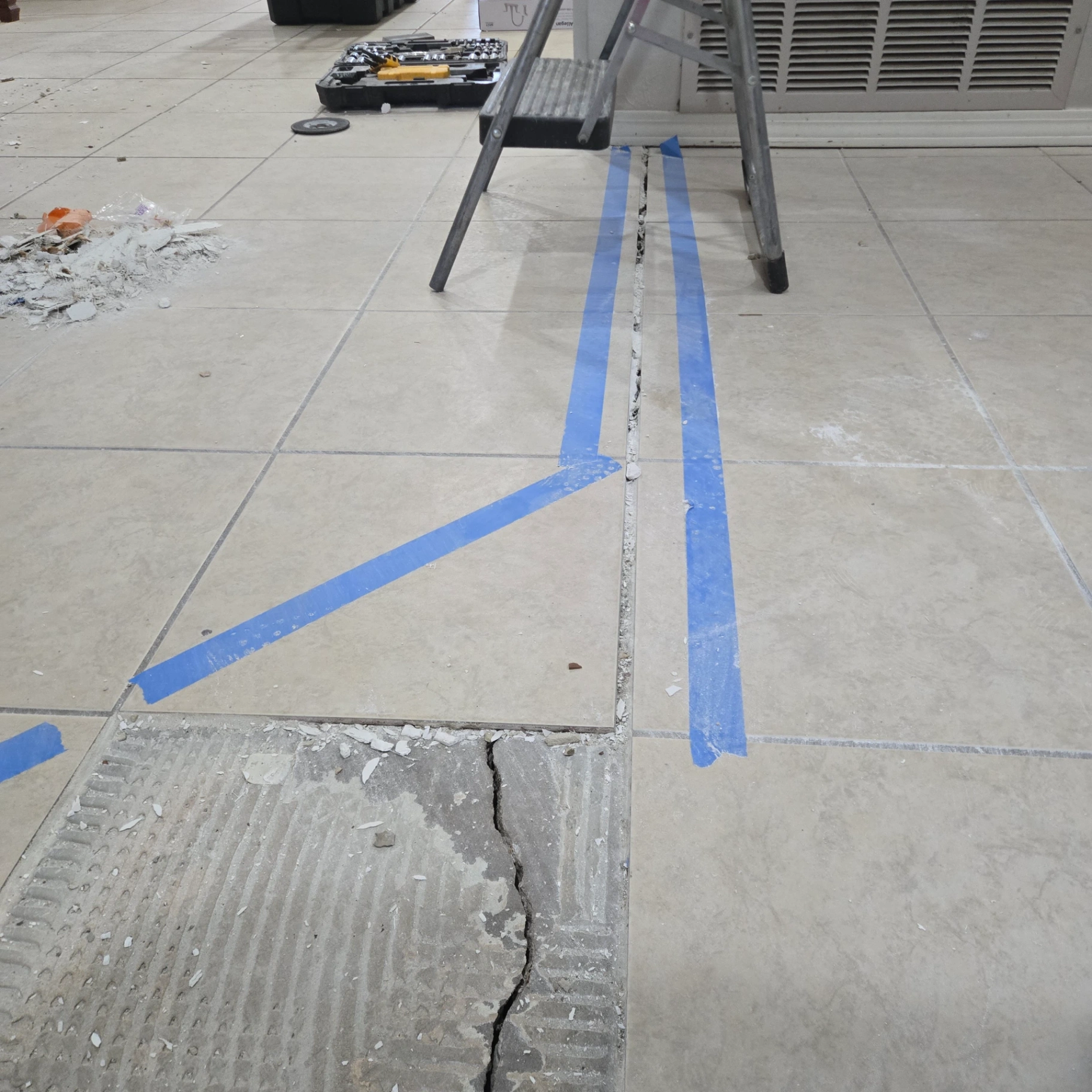 Floor tile repair project with tiles marked for replacement in Stillwater kitchen