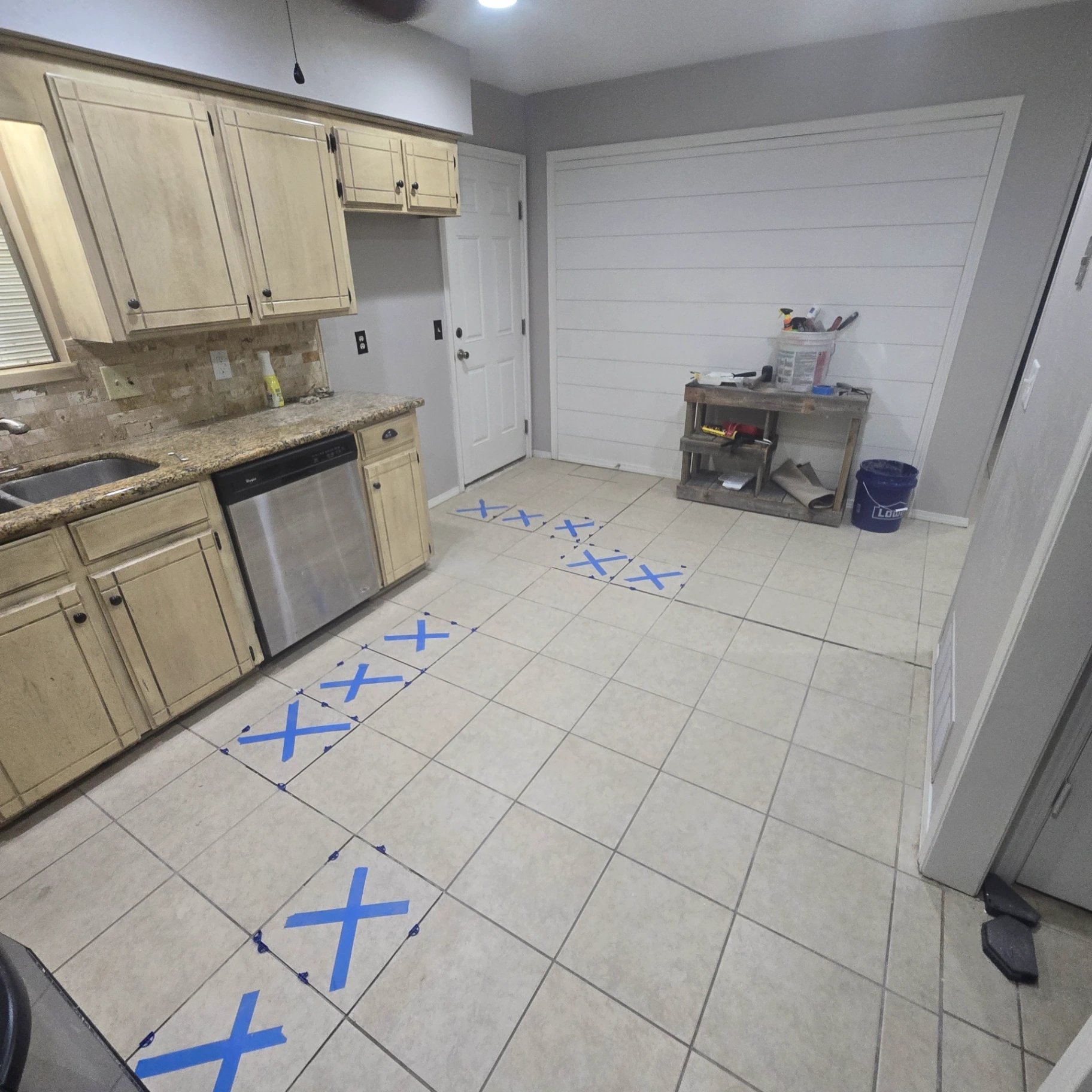 Kitchen floor tile installation preparation with tile marked for replacement in Stillwater