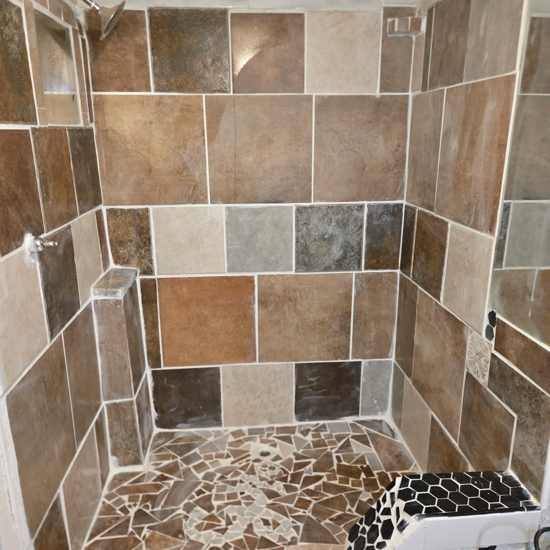 Custom tiled shower with mosaic floor and built-in niche in Stillwater, OK